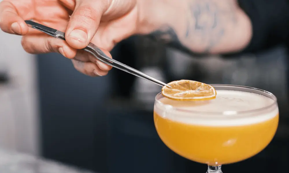 Het garneren van een rum sour cocktail met een schijfje gedroogde citroen
